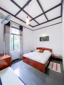 a bedroom with a large bed and a window at Serenity Home Stay in Kandy