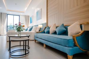 a living room with a blue couch and a table at Lotus Sầm Sơn Hotel in Sầm Sơn