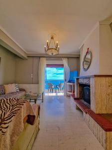 a living room with a fireplace and a view of the ocean at Poseidon's Balcony by Infinity in Nea Kalikratia