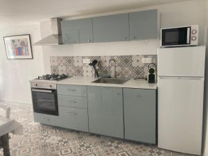 a kitchen with a white refrigerator and a sink at La Tanière du Ventoux in Bédoin