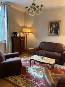 a living room with leather furniture and a table at Treignac in Treignac +1 photo
