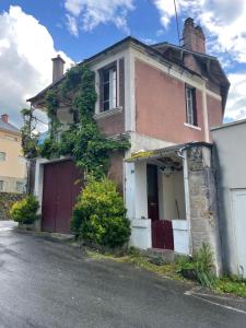 an old brick house with a garage on a street at Treignac in Treignac
