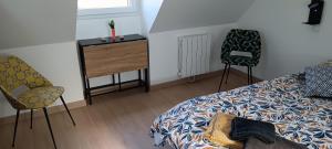 1 Schlafzimmer mit einem Bett, 2 Stühlen und einer Kommode in der Unterkunft Chambre d'hôtes in La Lande