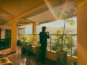 a man standing on a balcony looking at the view at Sapphire Lodges in Muzaffarabad