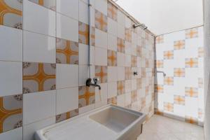 a bathroom with a tub and a tiled wall at Villino Airone in Torre Lapillo +20 photos