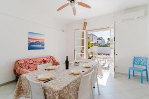 a dining room with a table and a couch at Villino Airone in Torre Lapillo