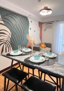 a dining room with a table with plates and chairs at The Sos Staycation in Davao City