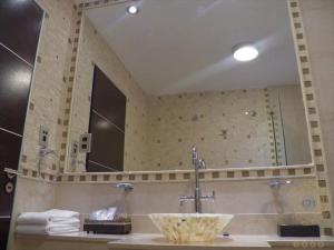 a bathroom with a sink and a large mirror at Casino Oberá Hotel in Oberá