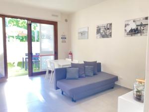 a living room with a blue couch and a table at NOVELLA DEL MAR prima fila dal mare in Grottammare +17 photos