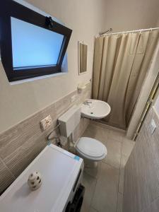 un bagno con un water, un lavandino e una finestra di camping Venere a Granelli Altre 37 foto