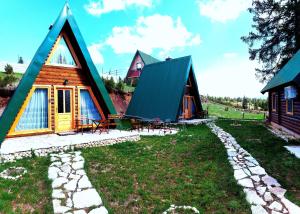 a group of cottages on a hill with a yard at M&K chalets in Žabljak