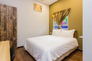 a bedroom with a white bed and a window at Hidden 5BR Cottage House Retreats (Free Parking) in Butterworth