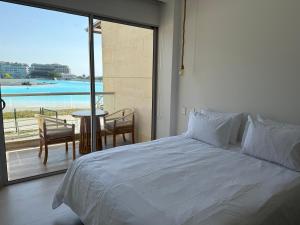 a bedroom with a bed and a balcony with a table at Apartamento Baia Kristal in Los Arrayanes
