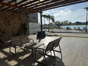 a patio with chairs and a table with a view of the beach at Apartamento Baia Kristal in Los Arrayanes
