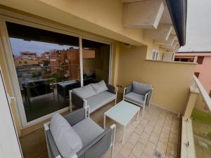 balkon z krzesłami, stołem i oknem w obiekcie R & D w mieście Alghero