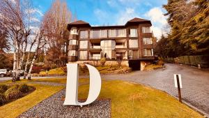 a large building with a sign in front of it at Design Suites Bariloche in San Carlos de Bariloche