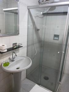 a bathroom with a sink and a shower at Quartos Privativos em Pousada Familiar Simples e Aconchegante in Itapira
