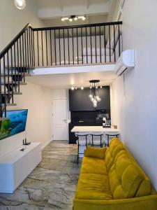 a living room with a yellow couch and a kitchen at Palanga Studio Apartment with a Pool in Palanga