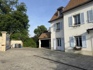 an empty driveway in front of a white building at Chestnut House Appartment in Le Mée-sur-Seine