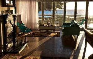a living room with a fireplace and a view of the ocean at Penguin Beachfront Apartments in Penguin