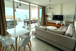 a living room with a couch and a table at MIKU Green Coast in Palasë