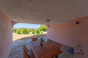 SchifoniにあるOasi Verde - Giardino e Parcheggio Privatoの木製テーブルと椅子付きのパティオ