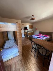 a room with two beds and a table in it at Car-es panzió in Veľký Meder