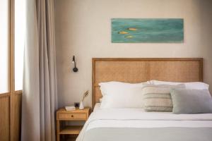 una camera da letto con un letto e un quadro sul muro di The Peach House a Chania