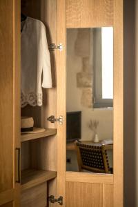 un mobiletto di legno con uno specchio in una stanza di The Peach House a Chania