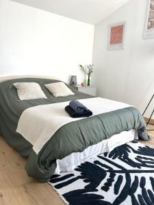 a bedroom with a bed with a blanket and a rug at La Chambre de Kerly in Pléguien