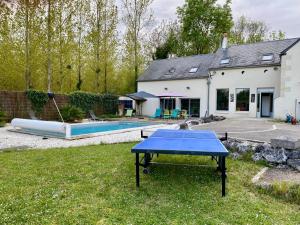a ping pong table in the yard of a house at Les Prairies du Val d'Amboise Grand Gite 15 pers avec piscine - PMR in Noizay
