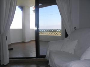 サアラ・デ・ロス・アトゥネスにあるApartamento Sol & Orillaのベッドルーム1室(ベッド1台付)が備わります。バルコニーの景色を望めます。