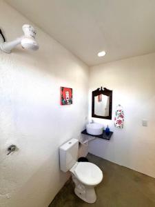 a bathroom with a white toilet and a sink at Suíte 8 - Village Capixaba in Gravatá +10 photos