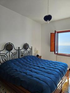 a bedroom with a blue bed with a window at Casa Il Panorama in Praiano