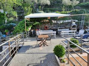 a patio with a table and a white umbrella at Apartments and rooms Roberto B. in Valun