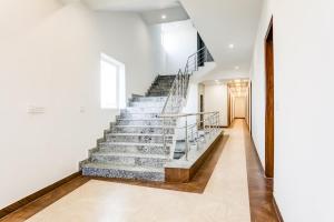 una scala in una casa con pareti bianche e pavimenti in legno di Hotel O The Grand Blue Hotel a Noida