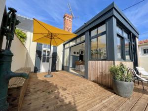 een grote gele paraplu op het terras van een huis bij Villa Georgette in Saint-Gilles-Croix-de-Vie