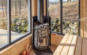 a wood stove in a room with two windows at Amazing Home In Perstorp With Sauna in Perstorp