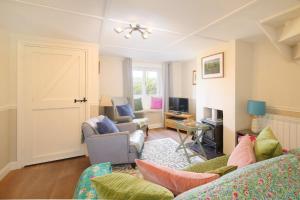 a living room with two couches and a tv at 18th Century Thatched Cottage Parking & Garden in Beaminster +56 photos