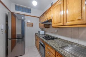 a kitchen with wooden cabinets and a stainless steel refrigerator at Piso Tazacorte in Puerto +14 photos