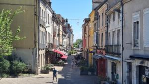 an alley with people walking down a street with buildings at Le Soleil-Levant centre-ville in Chalon-sur-Saône