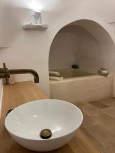 a bathroom with a white sink and a bath tub at Casalento in Ceglie Messapica
