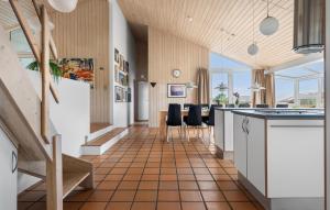 a kitchen and dining room with a table and chairs at Cozy Home In Hjørring With Sauna in Lønstrup