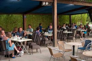een groep mensen die aan tafel zitten in een openluchtrestaurant bij Camping 4 étoiles - Piscine - ccb0dhf in Saint-Denis