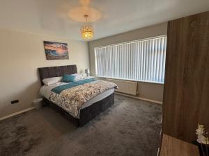 ein Schlafzimmer mit einem Bett und einem großen Fenster in der Unterkunft Modern 3-Bed Family Home in Quiet Sheffield Area in Wincobank