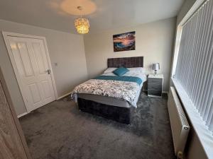 ein Schlafzimmer mit einem Bett mit blauen Kissen in der Unterkunft Modern 3-Bed Family Home in Quiet Sheffield Area in Wincobank