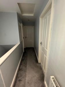 ein leerer Flur mit einer weißen Tür und einem Zimmer in der Unterkunft Modern 3-Bed Family Home in Quiet Sheffield Area in Wincobank + 2 Fotos