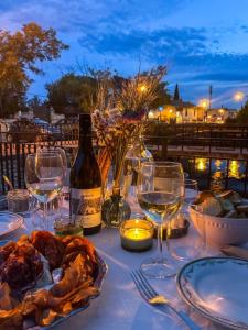 a table with wine glasses and a bottle of wine at La l'Isloise douceur de vivre à la Provençale in LʼIsle-sur-la-Sorgue