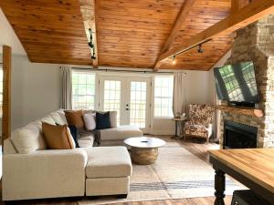 ヘンダーソンビルにあるFamily-Friendly Mountain Oasis W Game Room & Grillのソファと暖炉のあるリビングルーム