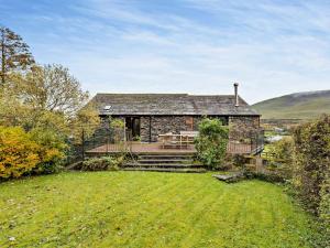 a stone house with a lawn in front of it at 3 Bed in Threkeld 93590 in Threlkeld